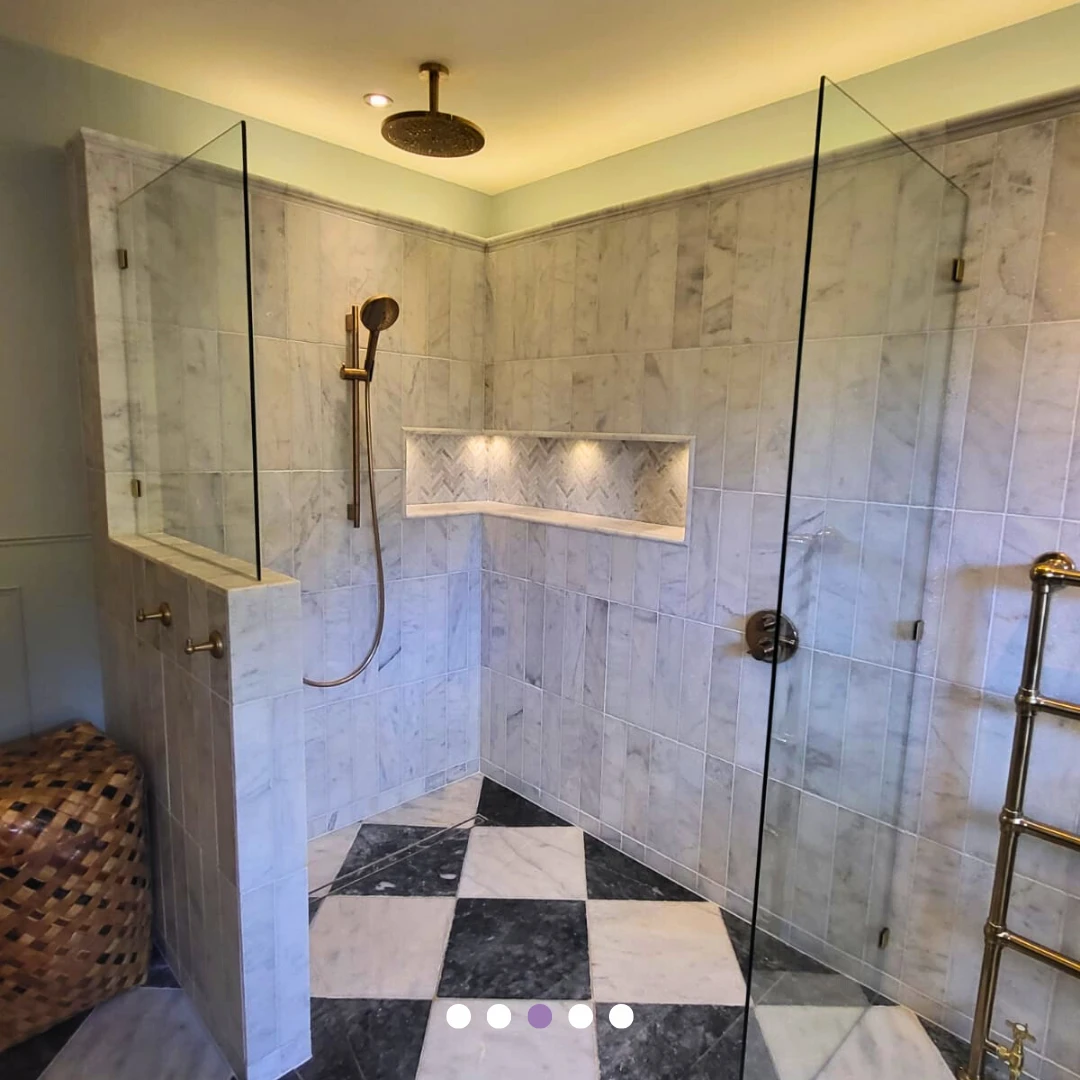 Walk-in shower with glass screens and an illuminated tiled niche